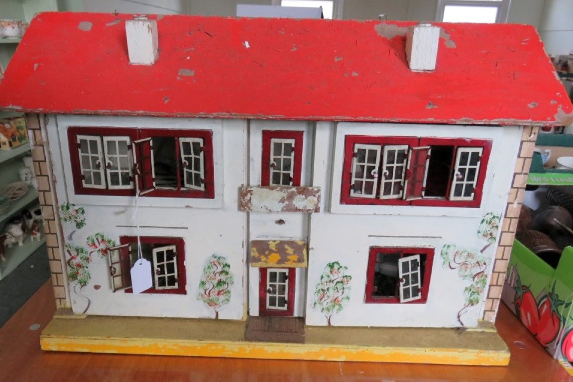 An early 20th Century painted wood dolls' house containing some furniture.