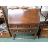 An early 20th Century oak fall front bureau. The base on turned short legs with box stretcher and