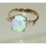 A 14ct gold opal and diamond ladies ring, set with a central oval cabouchon opal with a marquise cut