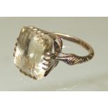 A 19th Century gold and pale citrine dress ring, claw mounted square cut stone, the ring band with