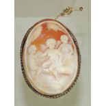 A large 9ct gold framed, oval cameo brooch. The shell cameo carved with three winged cherubs amongst