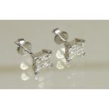 A pair of 18ct white gold diamond pierced earrings, each set with four square diamonds.