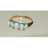 An 18ct gold ladies dress ring set with five graduated oval cabouchon opals (one A/F) and small