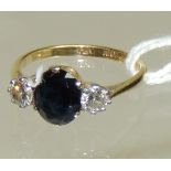 A ladies 18ct gold and platinum mounted diamond and sapphire ring. The central oval faceted sapphire