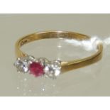 A ladies 18ct gold diamond and ruby ring set with a central ruby with a diamond to either side. Ring