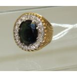An 18ct gold ladies dress ring, set with a large dark green, oval, faceted topaz with a surround