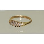 An 18ct gold ladies ring, set with a row of five graduated diamonds, ring size N.