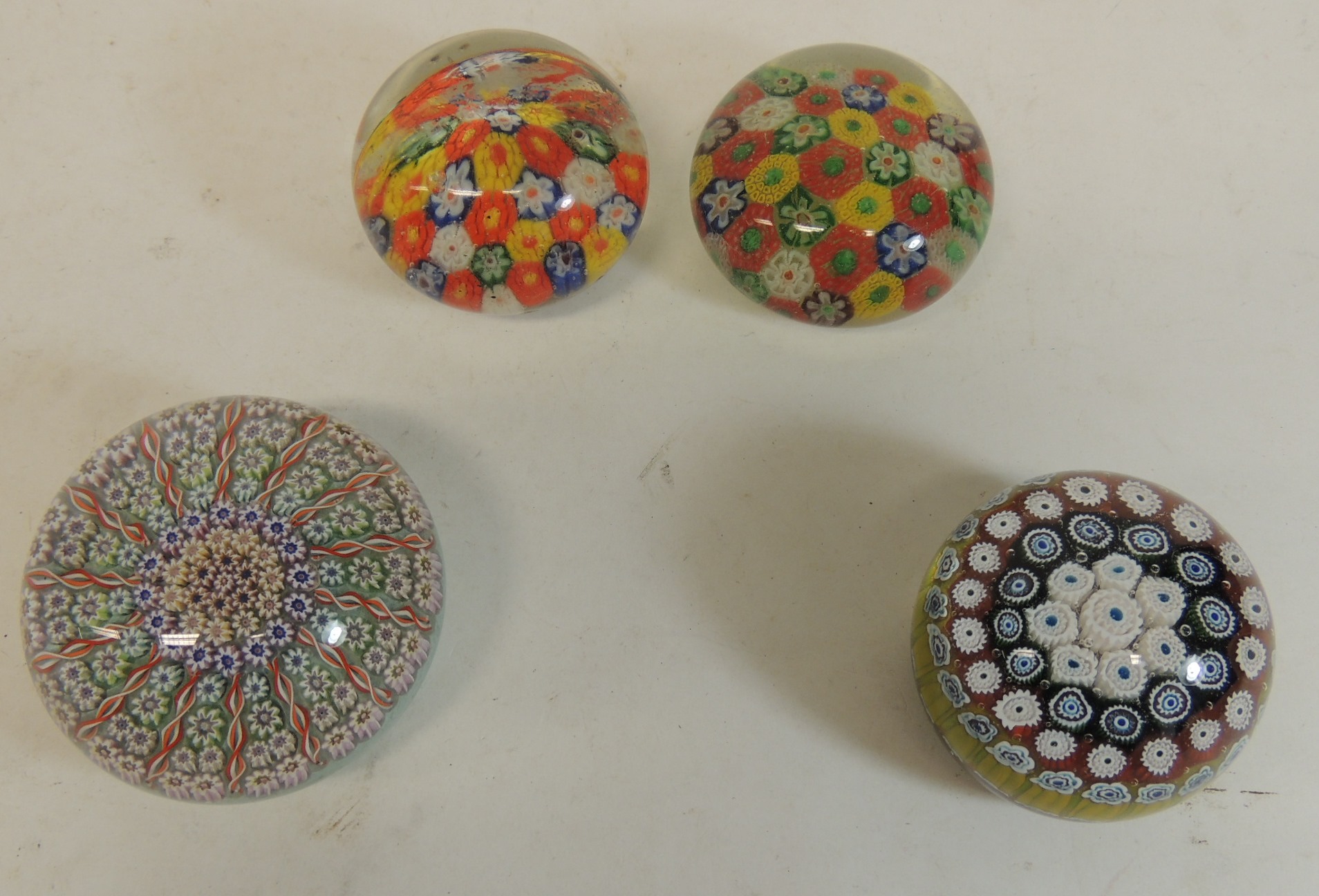 A 20th Century glass millefiori paperweight with flower head and spiral twist design; another