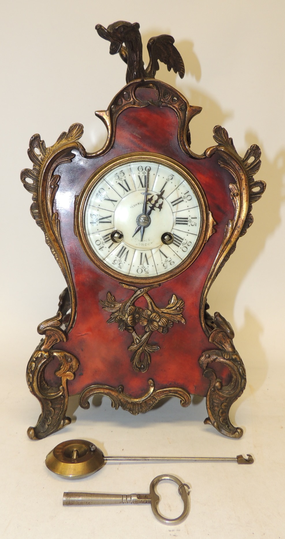 A late 19th Century French mantel clock by Mougin, having circular white enamel dial with black