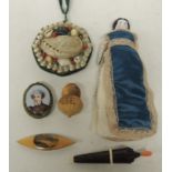 A Mauchlinware tatting shuttle with "Ilfracombe" image; a German porcelain doll needle holder; a