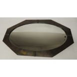 An Arts and Crafts wall mirror of shaped rectangular form having planished brass frame and