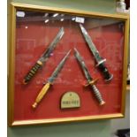 A modern glazed display of four reproduction commando knives with a plaque inscribed ''International