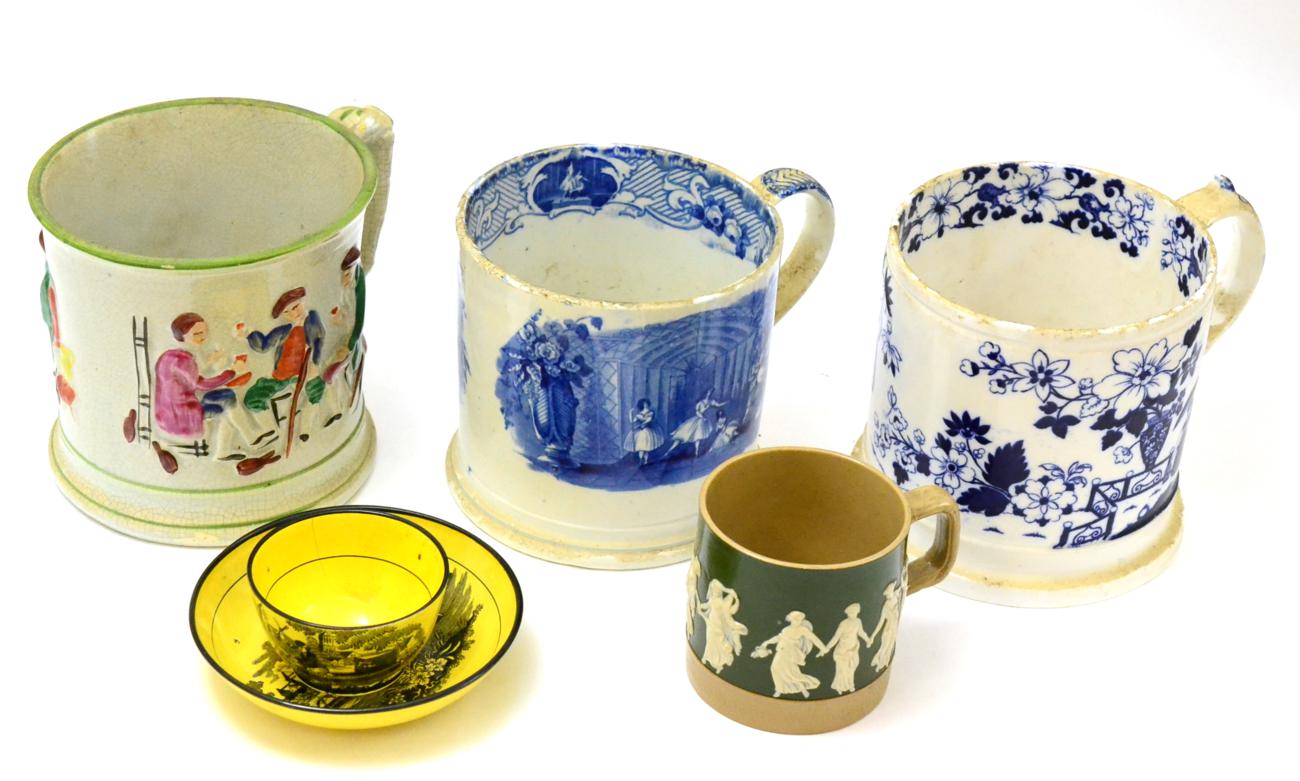 A collection of four Staffordshire mugs and an 18th century yellow glazed tea bowl and saucer by