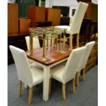 Modern kitchen table with white painted legs and six cream upholstered chairs