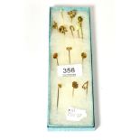 A group of thirteen stick pins; three stamped '9CT', three stamped '15CT, one stamped '14CT', the