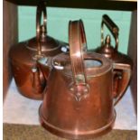 Two large copper kettles and a jug with carrying handle