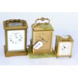 A brass four-glass carriage clock and two modern carriage clocks