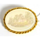 A Victorian reverse engraved glass brooch with mother-of-pearl reflector and yellow mount