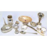 A silver caster, a silver topped dressing table pot, a silver mounted shell, four napkin rings and