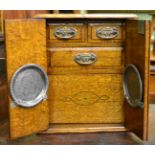A late Victorian blond oak smokers cabinet fitted with a revolving compartment fitted with an