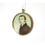 A 19th century portrait miniature on ivory of a young gentleman, in a yellow metal mount and