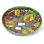 A Walter Moorcroft flambe leaf and grape pattern bowl Marks and scrapes, some loss to the pain in