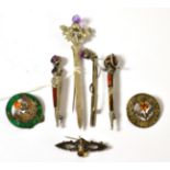 A Scottish hardsone kilt pin, two others, two thistle brooches, a golf brooch and another