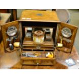 A late Victorian blonde oak smokers cabinet, Chapman's patent with numerous accessories including