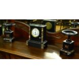 A black slate and marble clock garniture, of architectural form flanked by urns