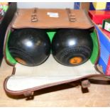 A set of four ebonised lawn bowls, in case