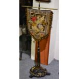 A Victorian ebonised pole screen with painted and gilt decoration, with a wool and bead work