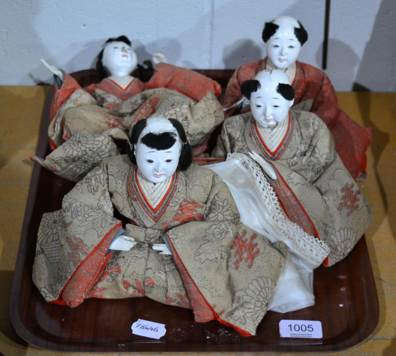 Four early 20th century Japanese seated figures, wearing brocade kimonos