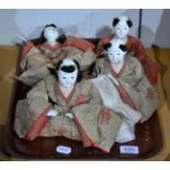 Four early 20th century Japanese seated figures, wearing brocade kimonos