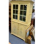 A small cream painted glazed kitchen cabinet