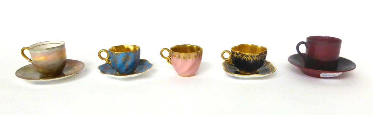 * A Royal Doulton named castle decorated cabinet cup and saucer; a similar flambe cup and saucer;