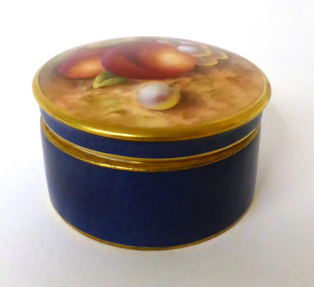 * A Royal Worcester blue ground circular box and cover painted with fruit by Roberts