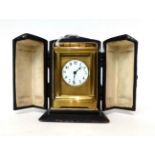 * A small brass carriage timepiece, circa 1900, carrying handle, enamel dial with Arabic numerals,