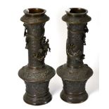 A pair of 19th century Chinese bronze vases each cast with dragons in relief