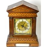 ~ A walnut quarter striking table clock, circa 1890, architectural pediment, base with a