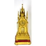 A gilt metal striking Cathedral form mantel clock, circa 1850, surmounted by a concealed bell,