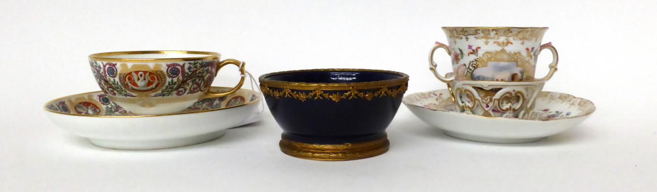 * A Meissen style twin-handled chocolate cup and trembleuse saucer painted with figures in