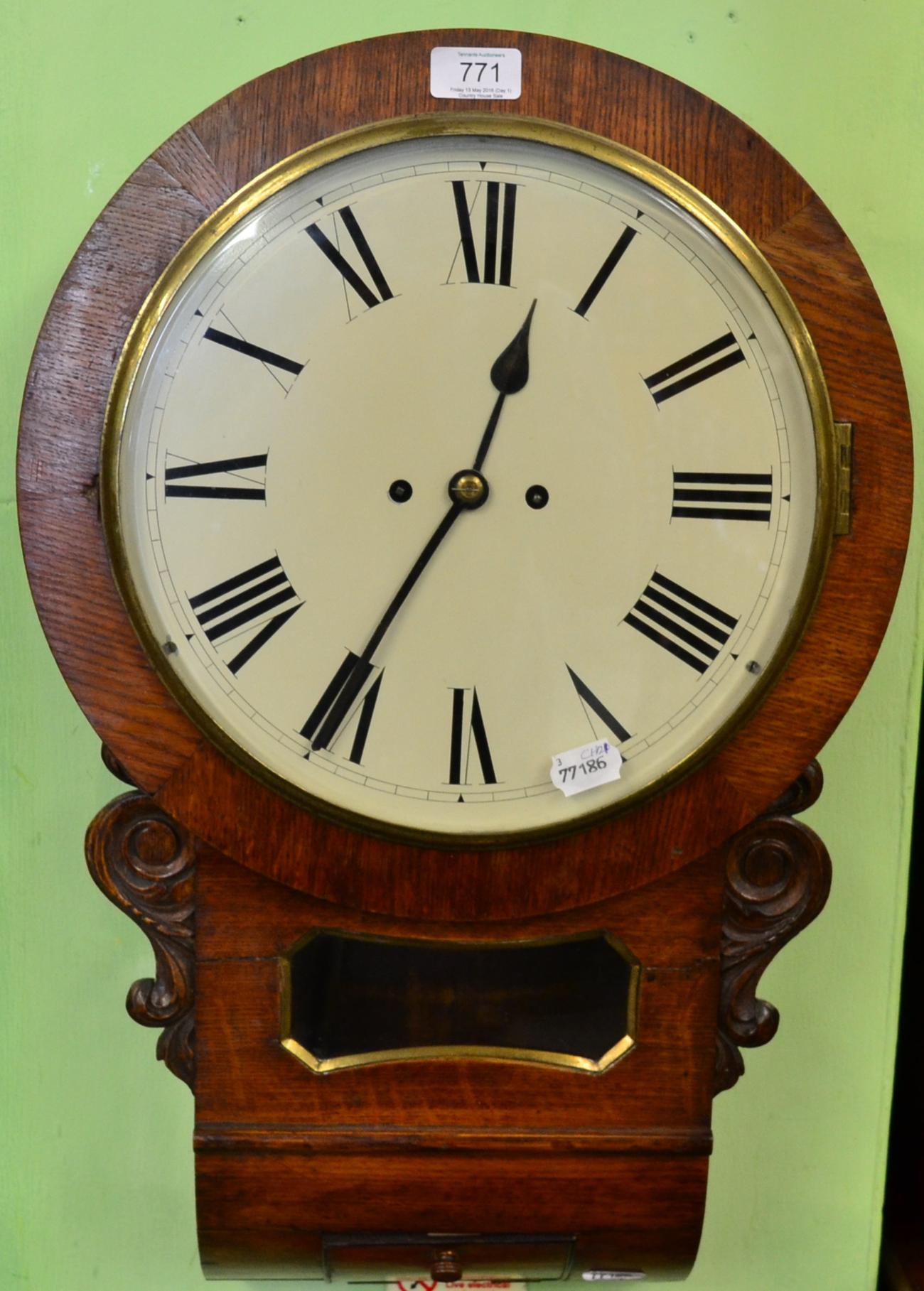 An oak drop dial striking wall clock, circa 1880, side and bottom doors, trunk with a pendulum