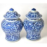A pair of 19th century Chinese jars and covers, painted in underglaze blue with phoenix amongst