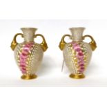 * A pair of Royal Crown Derby porcelain twin-handled vases painted with pink roses on a gilt ground,