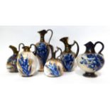 * A Doulton Burslem Flow Blue baluster ewer, 27cm; a similar smaller ewer, 22cm; and four various