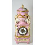 A porcelain pink ground mantel timepiece, 20th century, surmounted by an urn finial and cover,