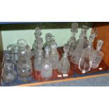 A shelf including fourteen 19th century and later moulded and cut glass decanters with stoppers