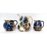 * A Doulton Burslem Flow Blue jug, 20.5cm; and a similar jug, 14cm; and and a similar jug, 13cm