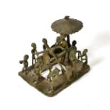An Asante Bronze Figure Group, modelled as a chief holding a gun, seated in a palanquin beneath a