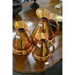 Three graduated copper jugs